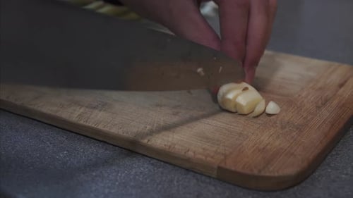 Chopping Garlic in Kitchen for Cooking Preparation