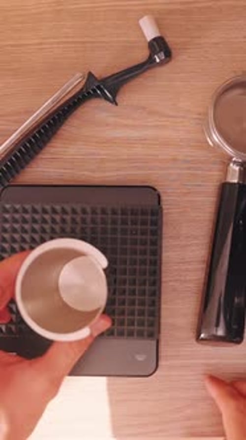 Vertical video. Top View of Man arranging Espresso Brewing tools on wooden table with Warm Light,