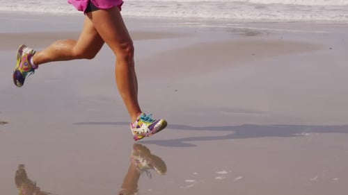 Woman jogging on tropical beach in costa rica slow motion close up