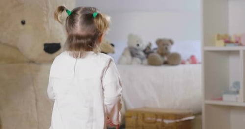 Happy Girl Dancing in Bedroom with Giant Bear