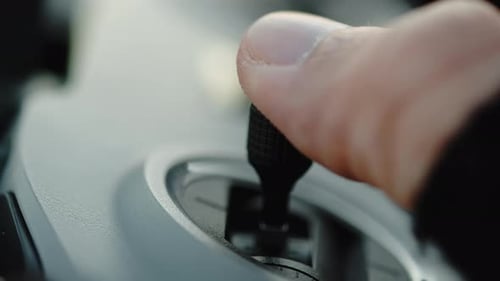 Hand Operating Black Joystick on Drone Controller