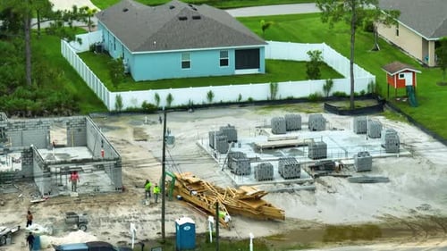 Construction Site of New Florida House Men Workers at Incomplete Frame of Private Home with Brick