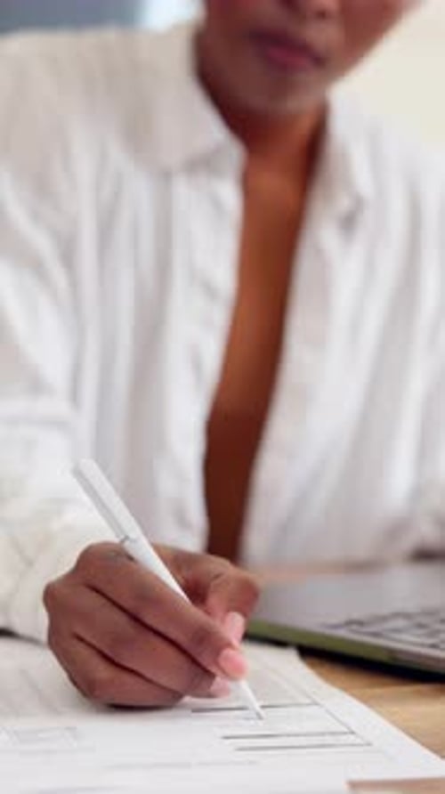 Person Completes Form Using Pen at Desk