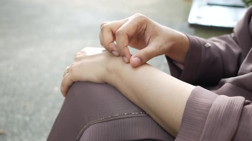Junge Frauen mit juckender Haut sitzen im Park