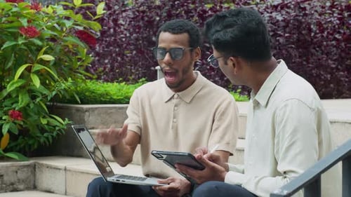 Diverse Colleagues Networking with Digital Devices on City Stairs