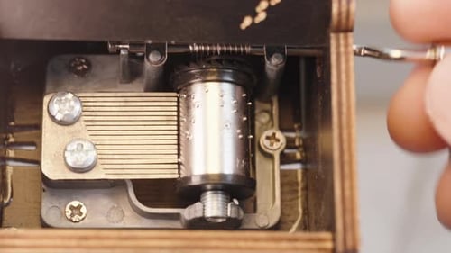 La main d'un homme joue avec une boîte à musique. Macro du mécanisme de la boîte à musique et des engrenages rotatifs Duri