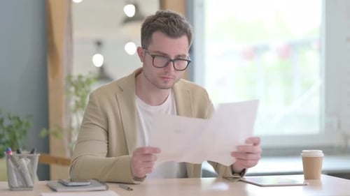 Excited Man Celebrates Reading Good News at Work