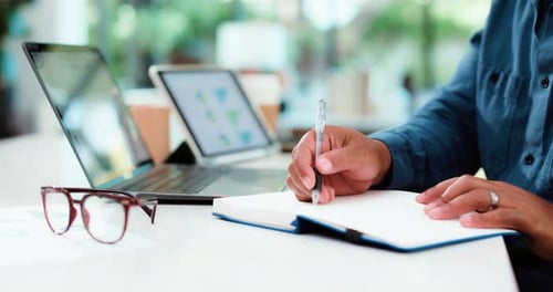 Professional Man Writing in Notebook at Office Desk