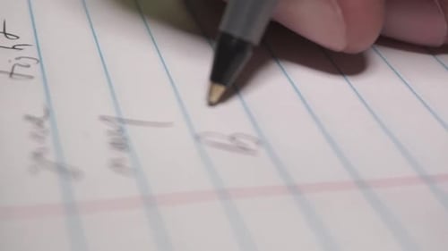 Close-Up Hand Writing on Lined Paper