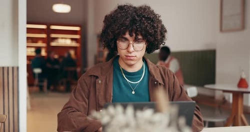 Business, man and reading with laptop at cafe for story ideas, editing article