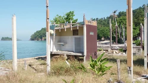 pan shot of a derelict beach bungalow in Thailand with ocean view