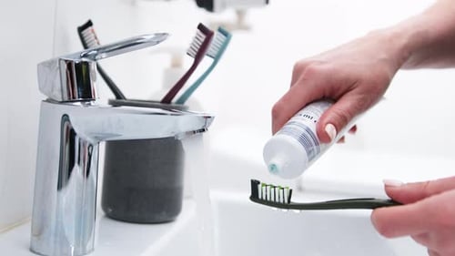 Girl'S Hand Applies Toothpaste To Brush