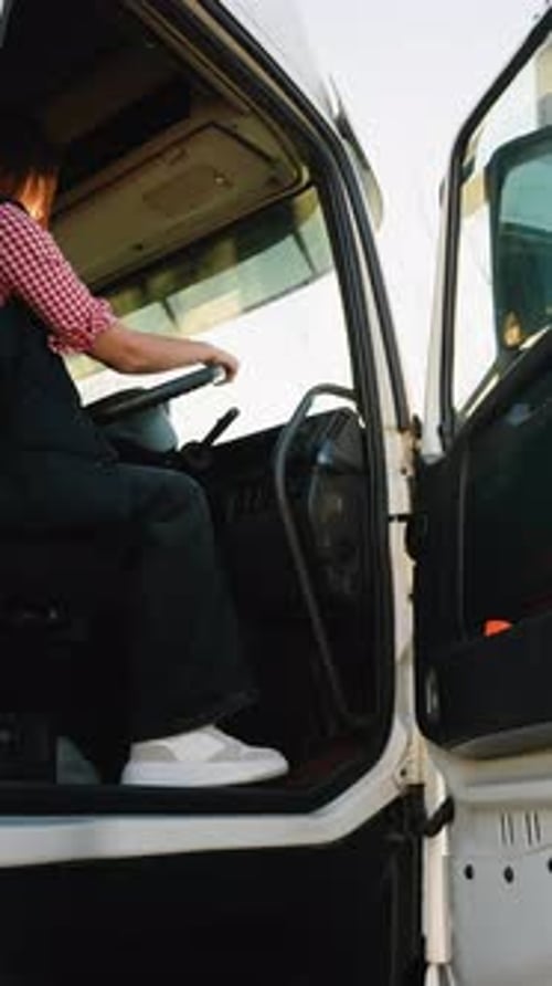 Female Truck Driver Seated in Righthand Drive Truck Preparing for a Trip