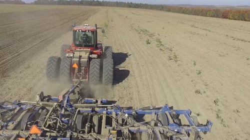 Big red combine working on the field cultivating and applying nitrogen ASP