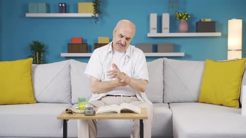 Mature Man Rubbing His Arms and Wrists