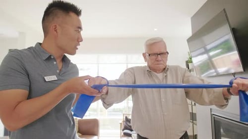 Man helps senior with exercise resistance band