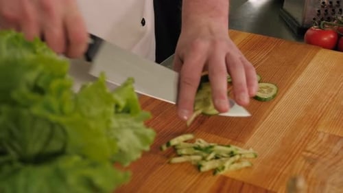 Chef Slices Fresh Cucumber in Kitchen