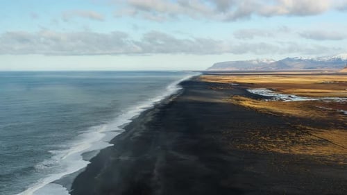 A vast black sand beach in iceland, showcasing the striking contrast between the dark shoreline and