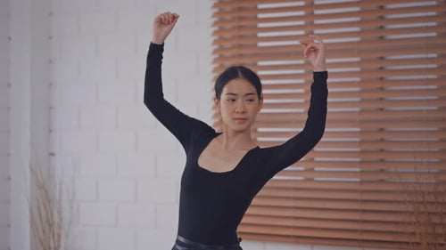Elegant Woman Practicing Ballet in Bright Studio