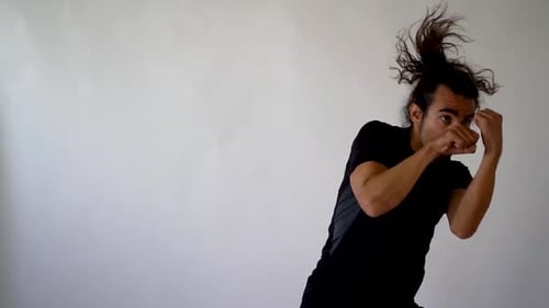 Long Hair Hispanic Boxer Shadow boxing on White Backdrop in slow motion, medium close up