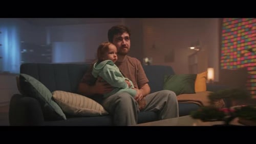 Father Holding Baby on Couch in Living Room