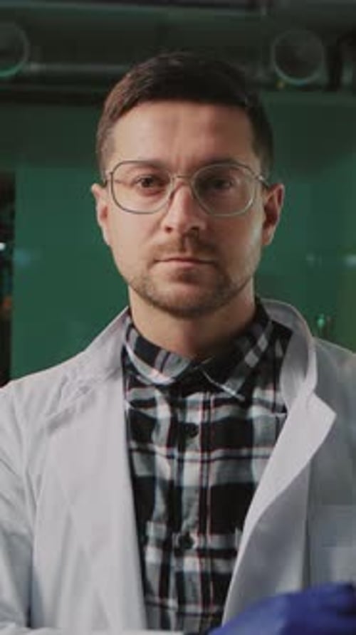 Close Up Handsome Cheerful Scientist with Glasses and Protective Gloves in a White Medical Uniform