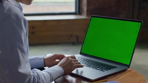 Person Browsing on Laptop With Green Screen