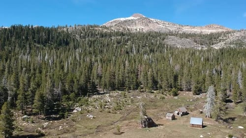 Aerial view mountain forest landscape with a meadow and cabins in California