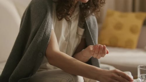Woman Takes Medicine and Drinks Water at Home