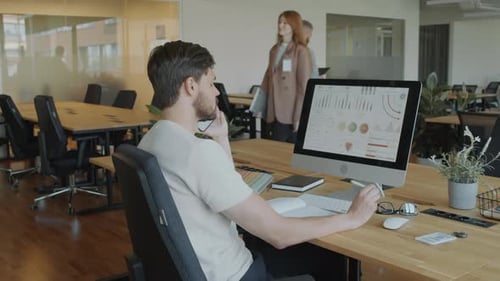 Office Worker Discussing Financial Data on Phone