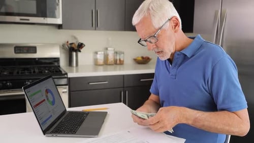 Mature man using a laptop paying bills