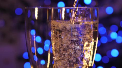 Bubbles sparkle in champagne glasses and spin slowly. Bubbles rise beautifully up in glasses. Blurre