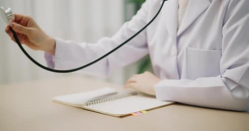 Close-up of a doctor's hand listening to a patient's heartbeat.