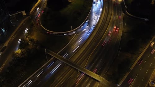 Hyperlapse d'un pont autoroutier par un drone pendant la nuit. La caméra à cardan du drone s'incline vers le haut et
les phares de la voiture