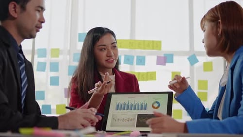 Young Professionals Collaborate on Data Presentation in Office