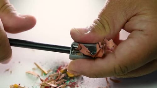 Footage of hands slowly sharpening a pencil and some coloured pencils with a Wedge Pencil Sharpener.