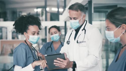 Medical Staff Reviewing Tablet in Bright Hospital Setting