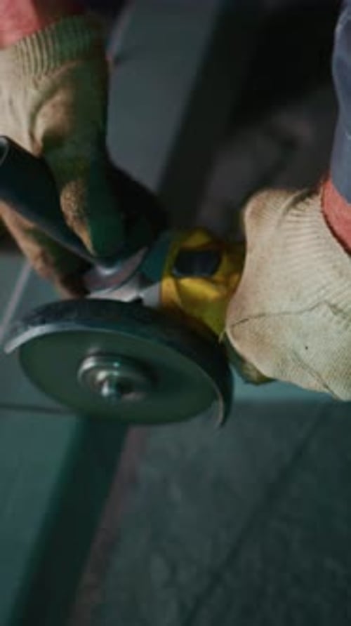 Worker Cuts Metal with an Angle Grinder Indoors