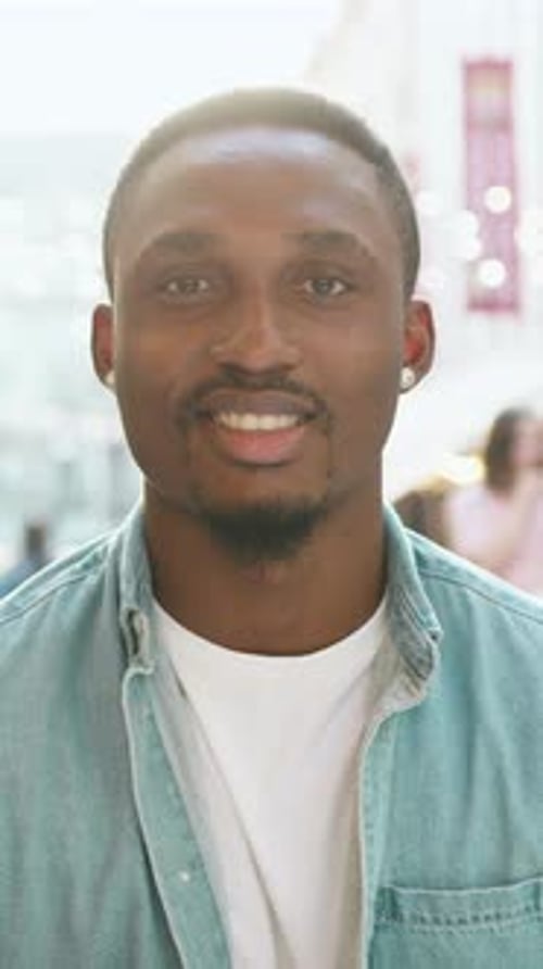 Smiling Young Man in Blue Denim Shirt Outdoors