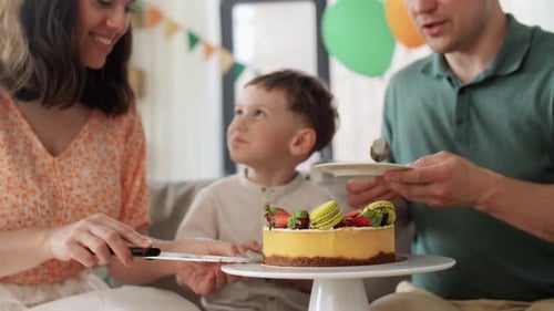Family cuts a cake at a birthday party