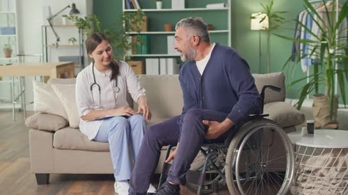 Doctor Consulting with Man in Wheelchair at Home