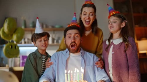 Family Celebrates Birthday with Cake and Balloons Indoors