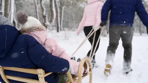 Happy Family Sledding on Snowy Winter Day Father and Mother Pull Sled with Son and Daughter on