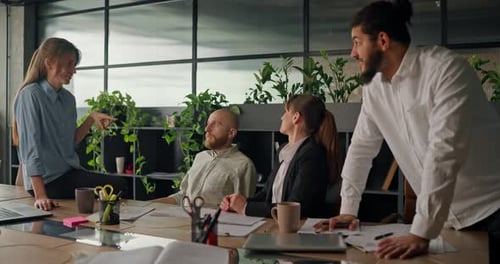 Office Worker Shares Ideas and Discusses Projects with Colleagues at the Table Engaging in Casual