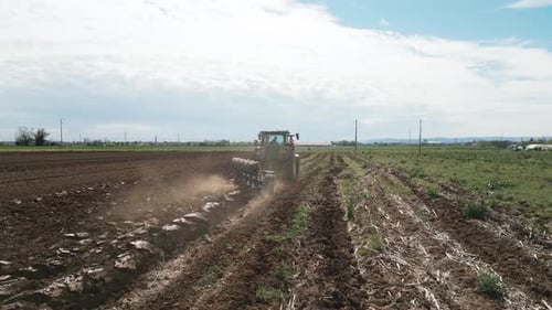 A Farmer Using a Tractor to Prepare the Fields for Planting The Image Highlights the Importance of