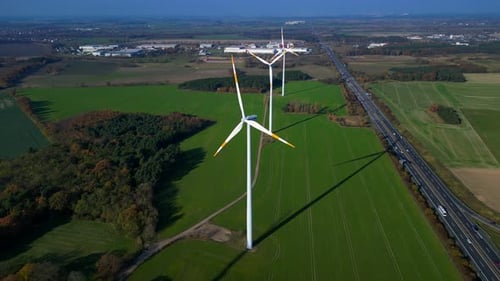 Wind farm Windmill turbines near highway clean energy. Nice aerial view flight drone