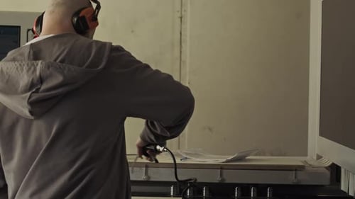 Woodworker Using Compressed Air Tool in Carpentry Workshop