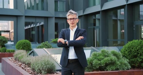 Confident Man in Suit Smiling Outside Office Building