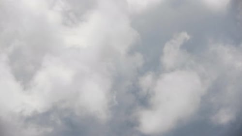 Blauer Sommerhimmel mit dichten, dicken Gewitterregenwolken, die sich über den Himmel bewegen. Schnelles Cloud-Formular