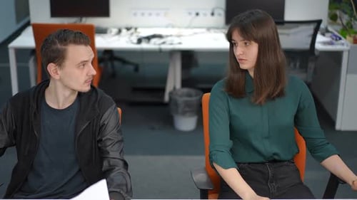 Front View Intelligent Young Man and Woman Discussing Business Sitting in Office Indoors